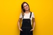 © luismolinero - Woman over yellow wall with glasses and smiling