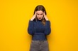 Teenager girl over yellow wall with headache