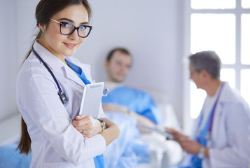 Female doctor using tablet computer in hospital lobby