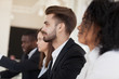 © fizkes - Workers sitting in row, close up focus on team leader