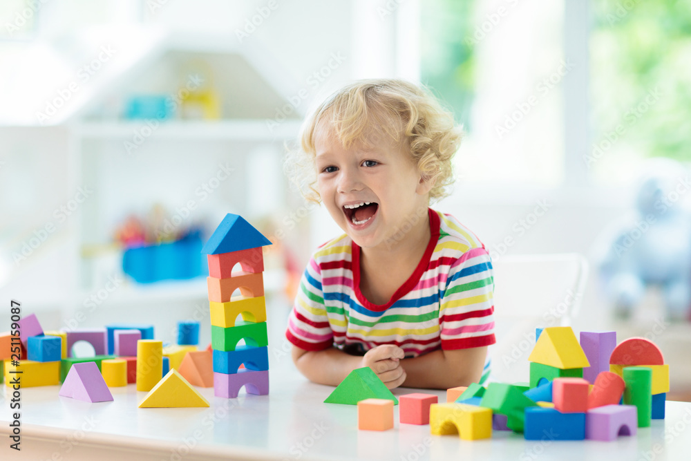Kids toys. Child building tower of toy blocks. - obrazy, fototapety, plakaty 