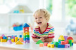 © famveldman - Kids toys. Child building tower of toy blocks.