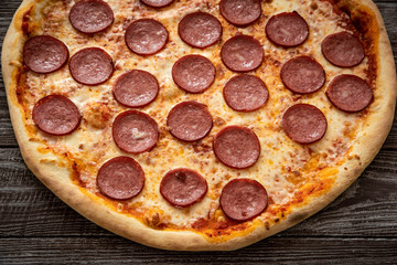 Pizza pepperoni on wooden table close up