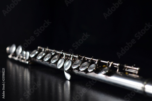 Cuadros en Lienzo Glossy silver transverse flute on a black background