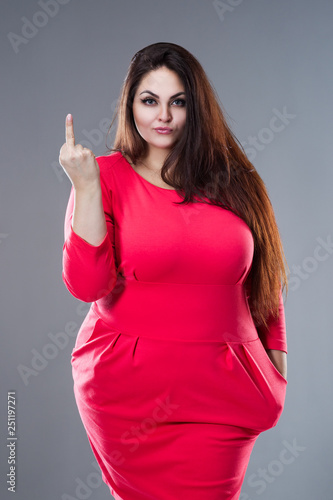 Beautiful plus size fashion model in red dress, fat woman with long hair showing fuck off sign ...