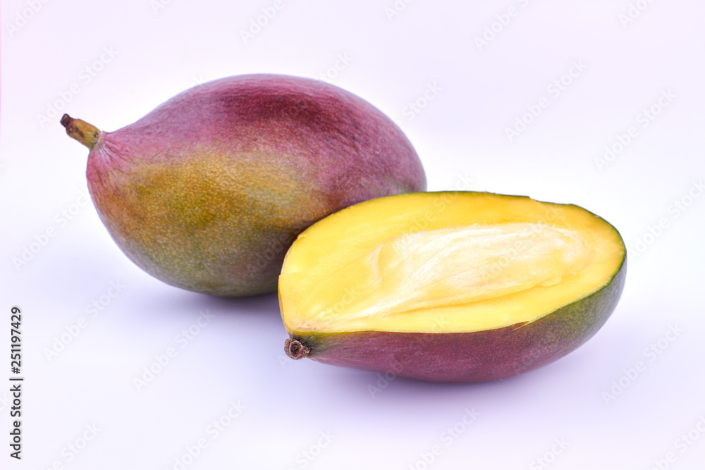 Whole and half of ripe mango. Ripe mango fruit on light background. Juicy exotic fruit. - obrazy, fototapety, plakaty 
