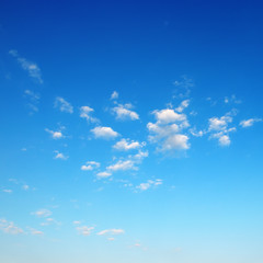 small fluffy clouds on bright blue sky
