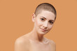 Beautiful mid 30s woman looking at camera with smile. Photo of attractive caucasian woman with perfect skin on beige background. Youth and Beauty concept.