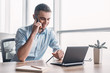 © Friends Stock - Portrait of businessman talking on mobile phone in office