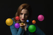 © frank11 - Low key portrait of sensual young woman sending a kiss with a open palm. Colorful empty balls ready for your use are flying around her.