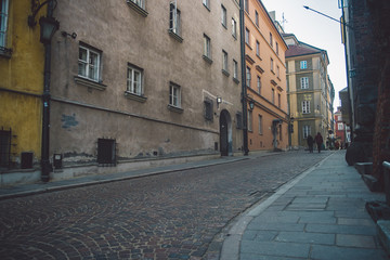 Ancient narrow Warsaw street with old architecture and winter background