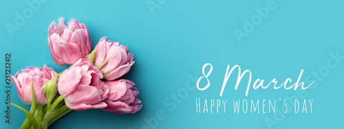 Pink tulips on turquoise background with copy space. Happy women's day greeti...
