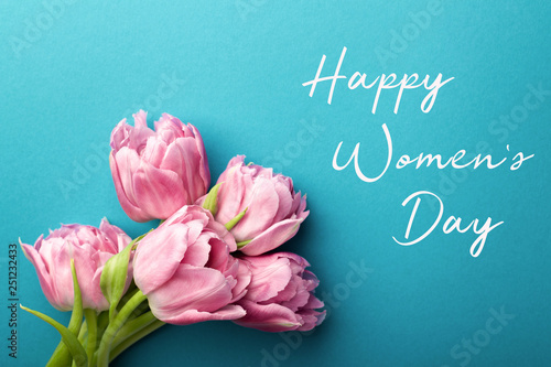 Pink tulips on turquoise background with copy space. Happy women's day greeti...