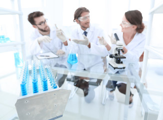 Wall Mural - background image of scientists studying blue liquid in a flask