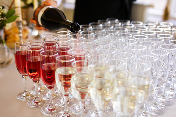 the waiter pours champagne in glasses on the street - wedding catering