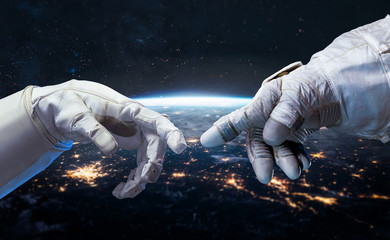 Leinwandbilder - Astronaut and robot hands in the space. Earth planet on the background. Communication and technology. Cities lights. Elements of this image furnished by NASA