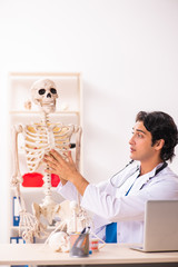 Young male doctor with skeleton 