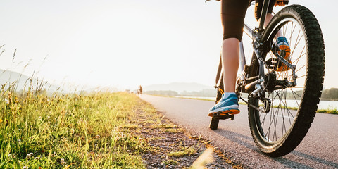 Woman feet on bycikle pedal in sunset light