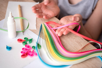 Quilling technique. Making decorations or greeting card. Paper strips, flower, scissors. Handmade crafts on holiday: Birthday, Mother's or Father's Day, March 8, Wedding. Children's DIY concept.