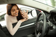 © Nestor - Shocked beautiful girl smiling, admire view of automobile cabin, gesturing by hands. Female customer choosing vehicle in modern car dealership, looking with shock at steering wheel through car window.