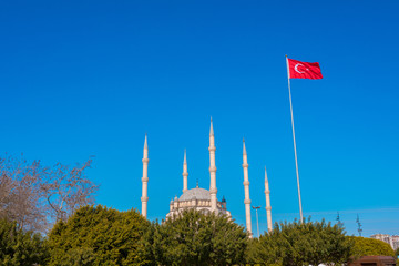 Wall Mural - sabanci central mosque and turkish flag in adana, seyhan city of turkey. turkish flag waving at blue