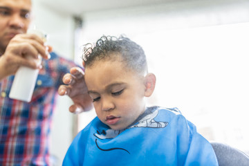 Wall Mural - Cute Boy Getting a Hair Cut in a Barber Shop. Beauty Concept.