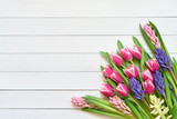 Fototapeta Tulipany - Spring flowers on white wooden background. Top view, copy space. Greeting card.
