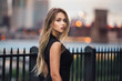 © Nick Starichenko - Beautiful woman with long blond hair walking in the city at evening time wearing elegant black dress