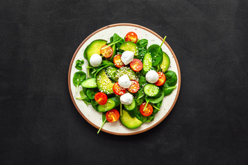 Wall Mural - Healthy lunch. Fresh vegetable salad on black background top view space for text