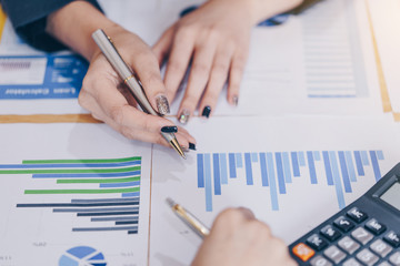 Businesswoman pointing pen on business document at meeting room.Discussion and analysis data charts and graphs showing the results at meeting.