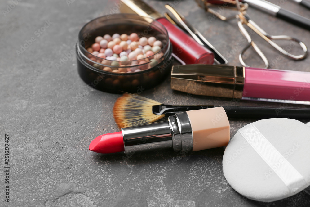 Professional makeup cosmetics with accessories on grey background