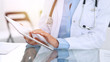 © rogerphoto - Female doctor hands using digital tablet  while sitting at glass desk at hospital office. Medicine and healthcare concept