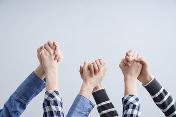 Wall Mural - Young women holding hands on light background. Friendship concept