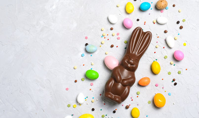 Wall Mural - Easter Bunny and Chocolate Eggs on Bright Background