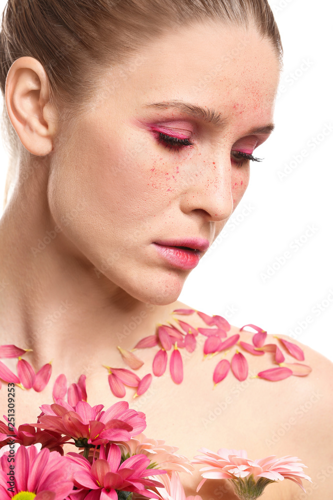 Beautiful woman with creative makeup and flowers on white background