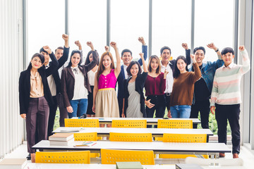 Successful of group of casual business relax celebrating their triumph with arms up in modern workloft.Teamwork concept