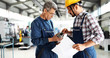 © NDABCREATIVITY - Team Of Engineers Having Discussion In Factory