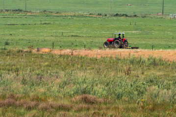 A red tractor working in a field.