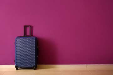 Packed suitcase near color wall