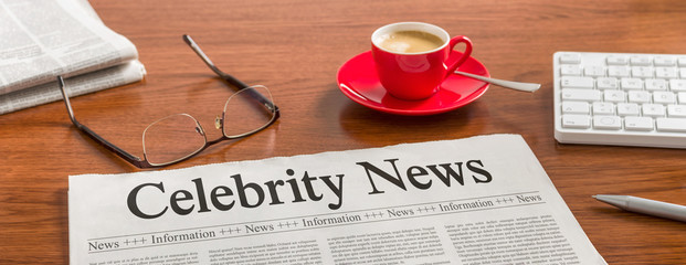 a newspaper on a wooden desk - celebrity news