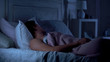 Man deeply sleeping on bed in dark room, comfortable mattress and pillows, dream