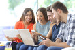 © Antonioguillem - Happy group of friends checking multiple devices