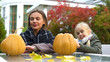 © motortion - Happy mother and daughter carving pumpkin jack-o-lantern for Halloween party