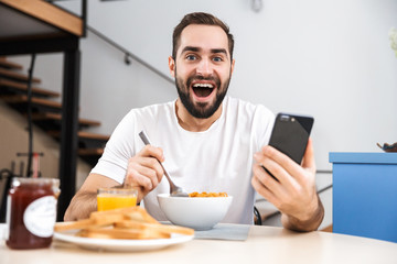 Wall Mural - Handsome young man having breakfast