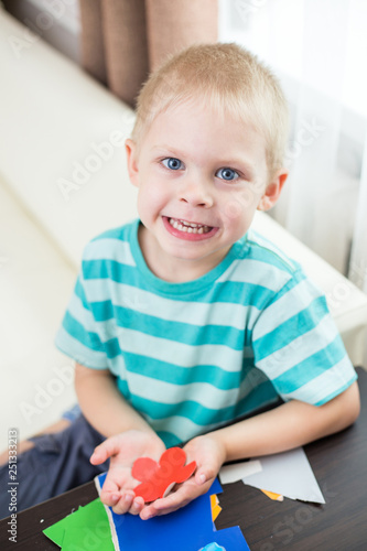 Little Cute Smiling Blonde Boy 4 Years Old Cuts Out Paper From