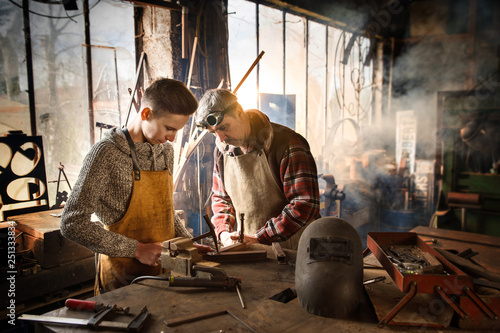 Fotomural A craftsman in his workshop teaches his work to his apprentice