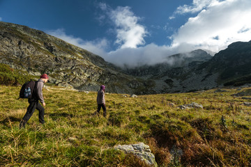 couple of hikers on a trail in the mountains