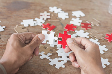 Close up of hands business women connecting jigsaw puzzleon, Teamwork workplace success and strategy concept.