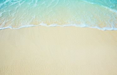 Sea wave on the sunny sandy beach.