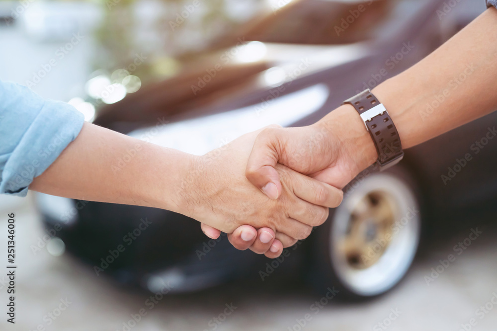 auto business. Close up of a business man dealer offer car to new owner and hand shake between two congratulations to customers. filter tone outdoor sunny in the morning.